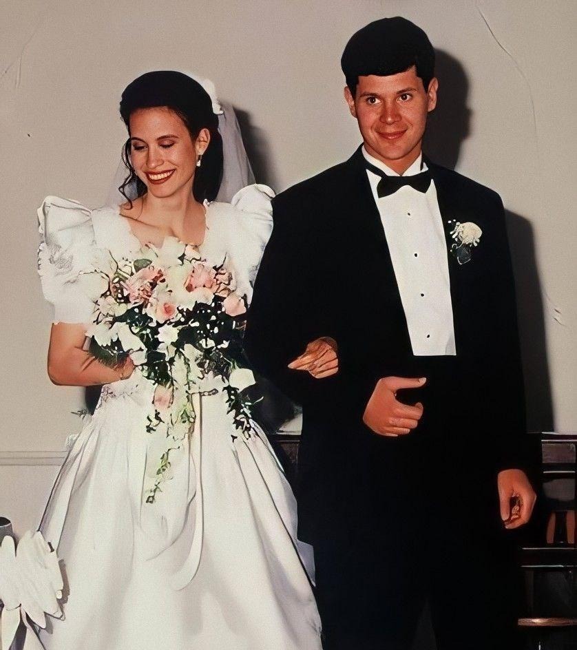 Свадебная фотография Андреа Йейтс (Andrea Yates) в белом платье с букетом и Рассела Йейтса (Russell Yates) в смокинге, улыбающаяся пара