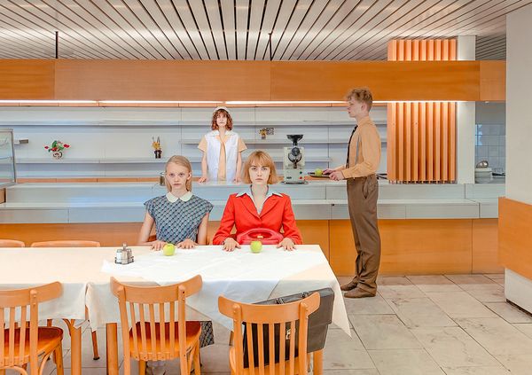 Женщина в белом халате лежит в ванне с песком и золотыми бликами