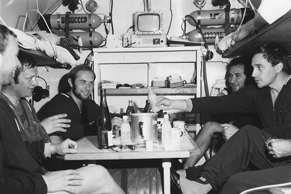 Акванавты за обедом внутри тесного жилого отсека подводной станции