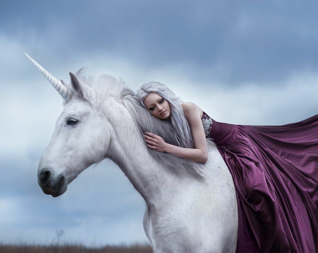 Классический белый единорог с длинным витым рогом на фоне леса