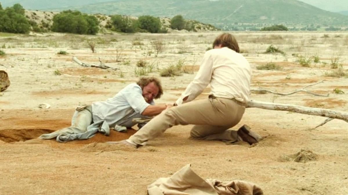 Кадр из фильма Невезучие: Жерар Депардье и Пьер Ришар в сцене, где один тонет в зыбучих песках, другой пытается вытащить