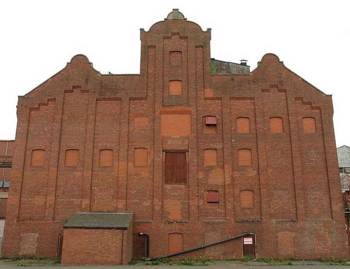 Фасад старинной церкви с заложенными кирпичом окнами