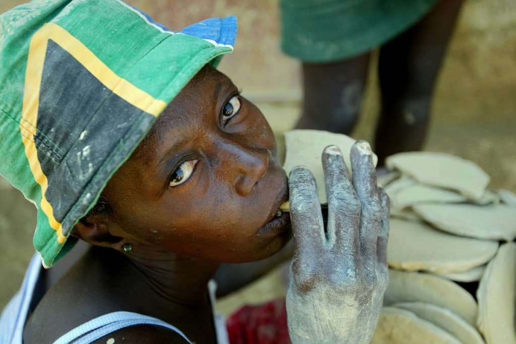 Женщина на Гаити ест глиняное печенье