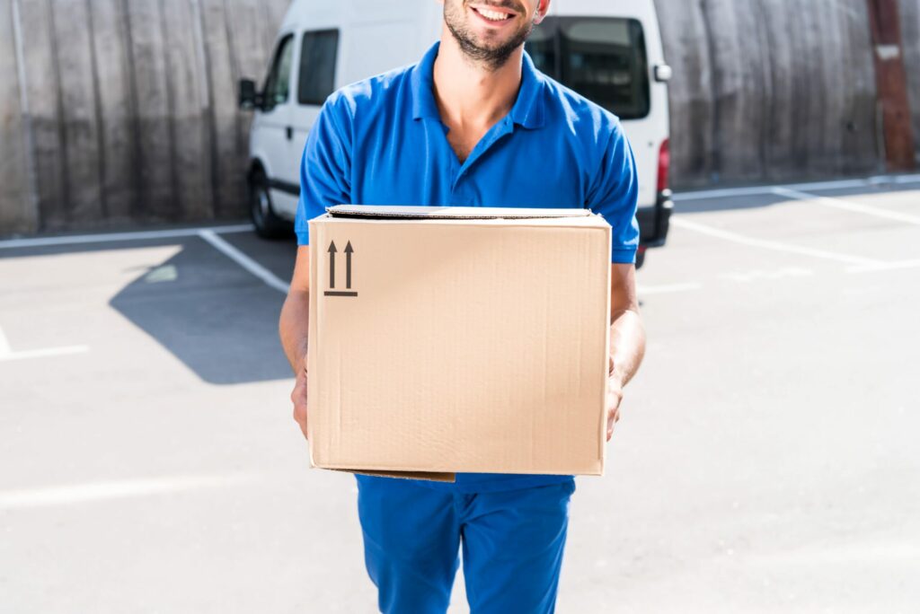 Bigpicture ru close up shot of smiling delivery man carrying car 2024 11 19 14 15 12 utc min scaled