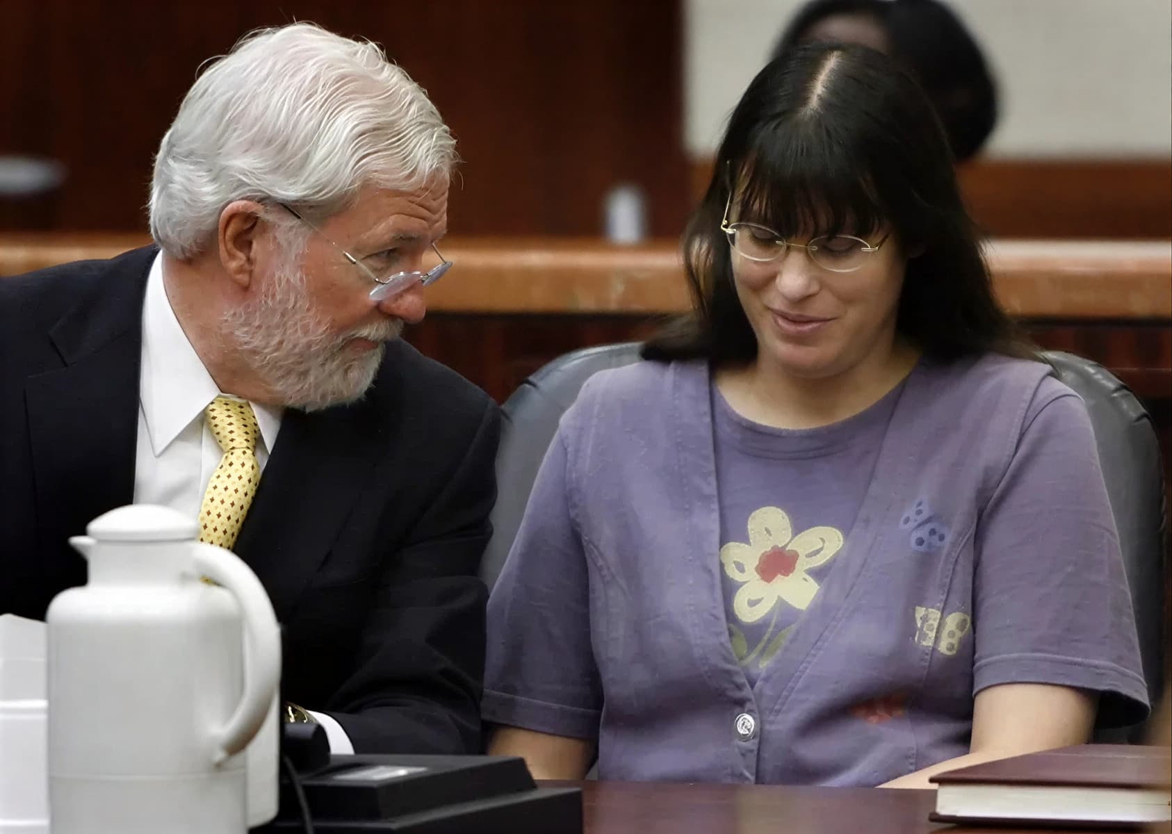 Андреа Йейтс (Andrea Yates) в фиолетовой кофте с цветком беседует с адвокатом в зале суда