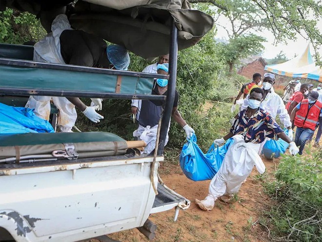 Полицейские и волонтеры переносят тела погибших от голода в машину