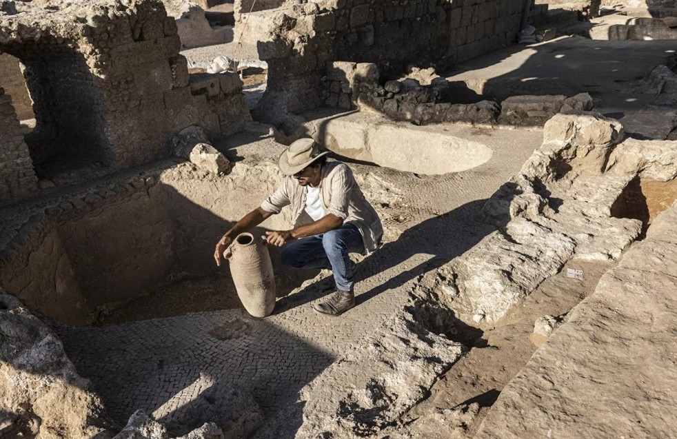 Археолог держит в руках древний глиняный кувшин для вина, найденный в Явне