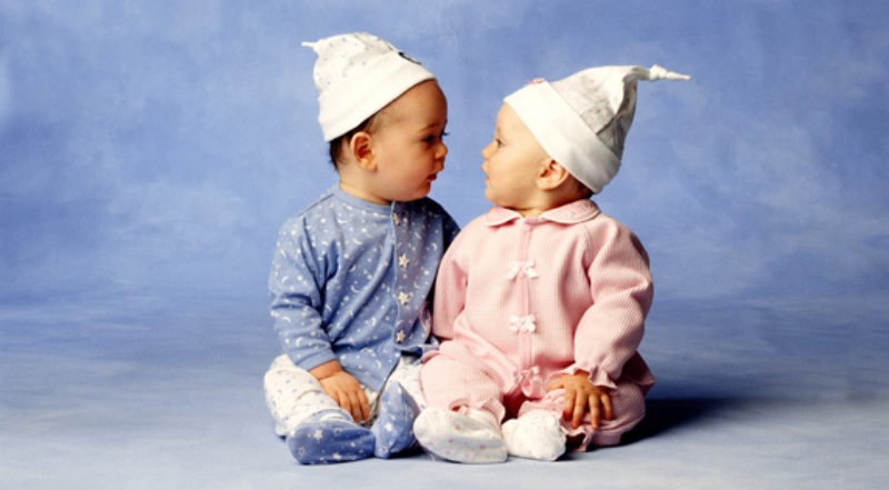 Два малыша в современной гендерной одежде: мальчик в голубом, девочка в розовом