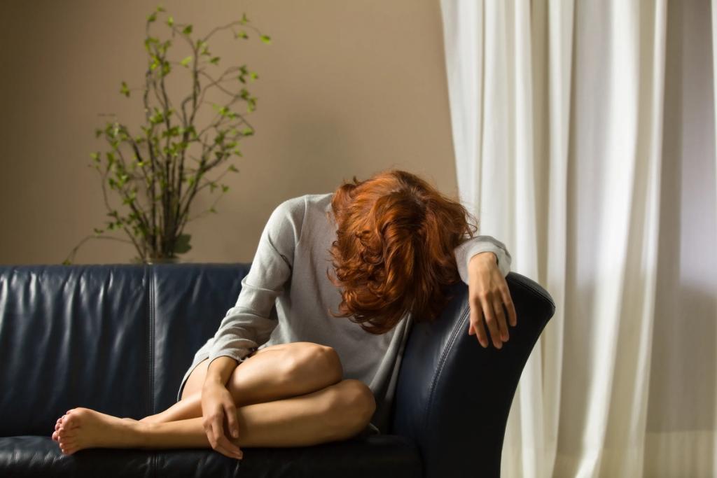 Девушка сидит на диване в апатии