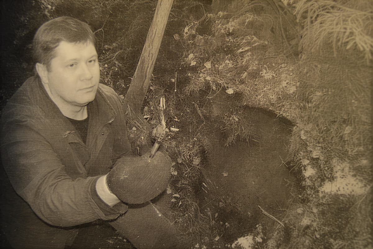 Следователь у лесного тайника Геращенко, где он хранил похищенное оружие