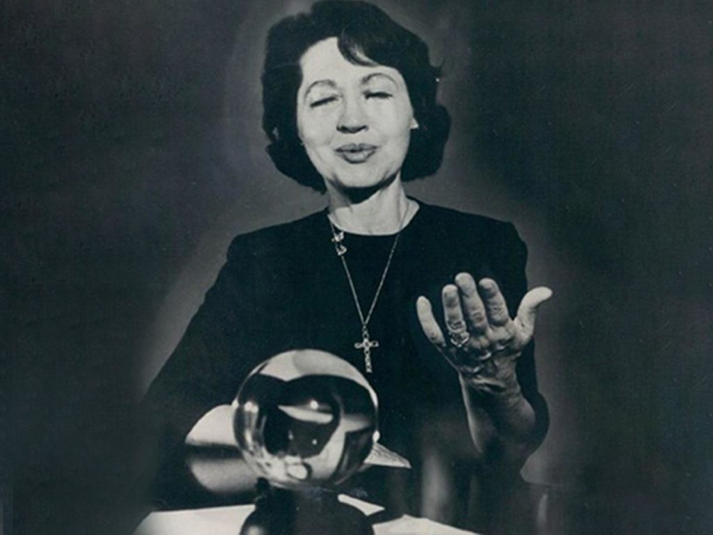 Пожилая Джин Диксон держит хрустальный шар на коленях