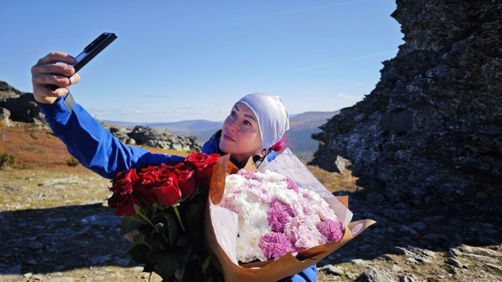 Оксана Лыткина в красивом платье на фоне уральских гор челлендж Урал на каблуках