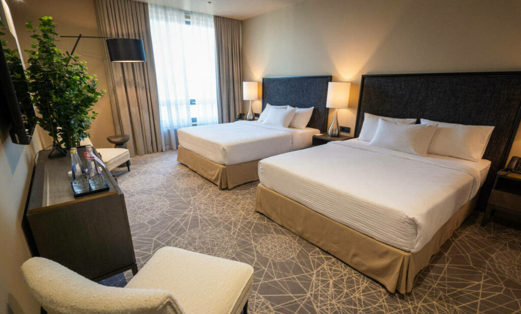 Уютная кровать с белым бельем и мягким освещением в отеле для сон-туризма