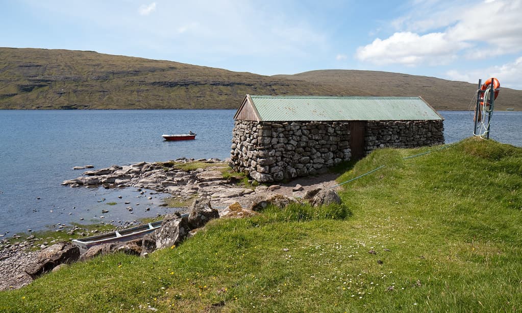 Каменистый берег и хижина у озера Сёрвогсватн Фареры