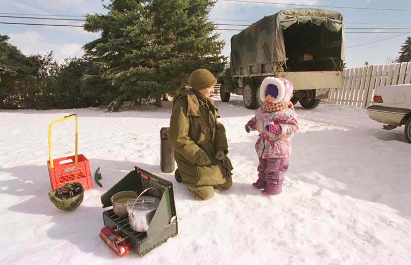 Военнослужащая канадской армии возле пункта раздачи горячей еды пострадавшим