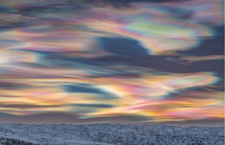 Яркие перламутровые облака над горизонтом после захода солнца