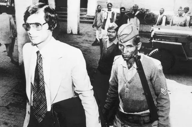 Шарль Собрадж в наручниках под конвоем полиции