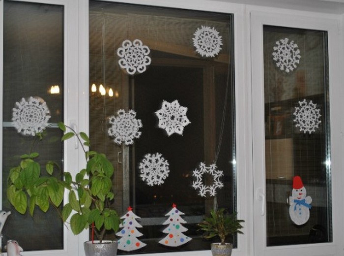 Окно, украшенное вырезанными бумажными снежинками и елочками в советском стиле