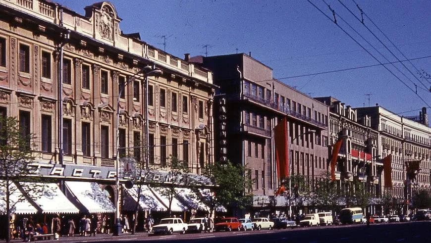 Фасад Елисеевского гастронома на Тверской улице в начале 1980-х с прохожими и припаркованными автомобилями