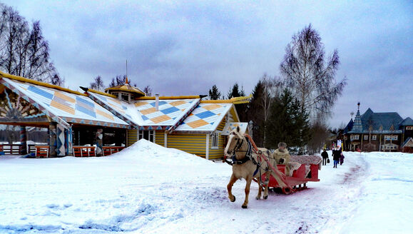 Традиционная русская изба с резными наличниками зимой в Мандрогах