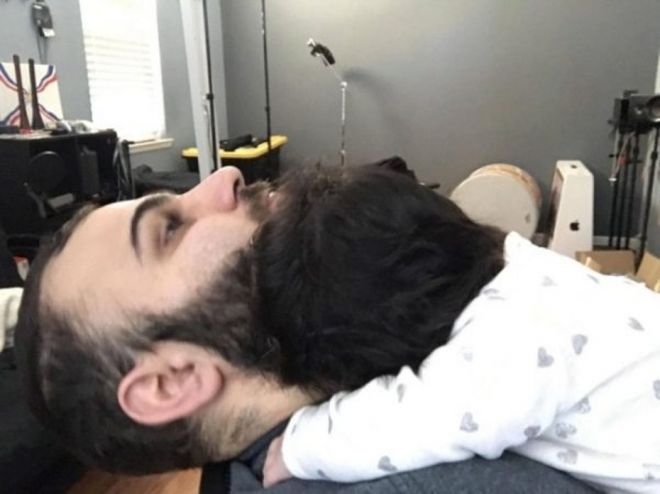 Смешной ракурс: отражение мужского лица в зеркале идеально накладывается на его подбородок, создавая вид бороды