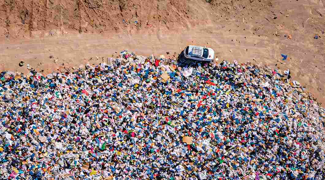 Контраст нетронутого песка пустыни Атакама и огромной кучи яркой выброшенной одежды