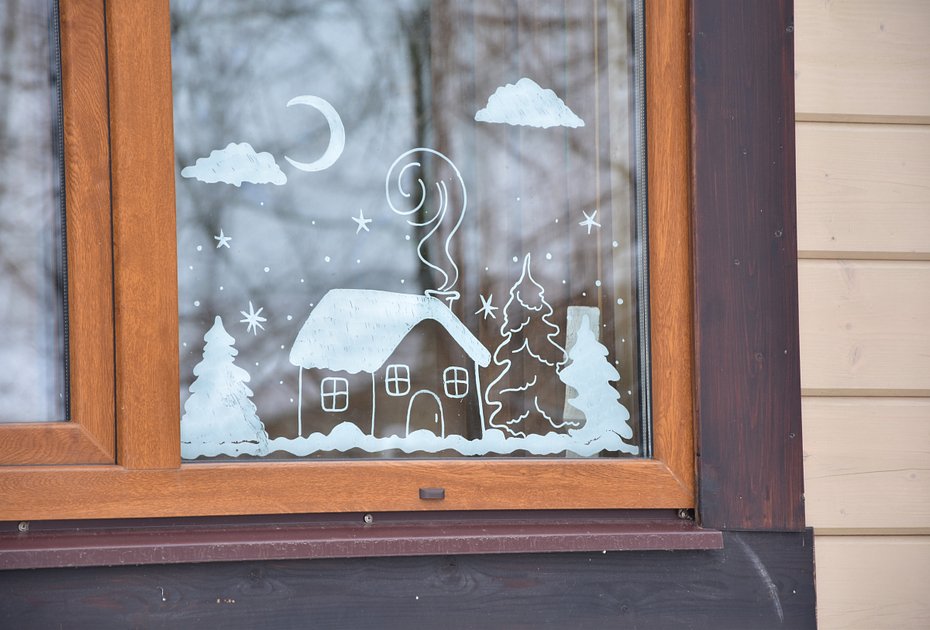 Простой зимний рисунок на оконном стекле с домиком, елками и месяцем