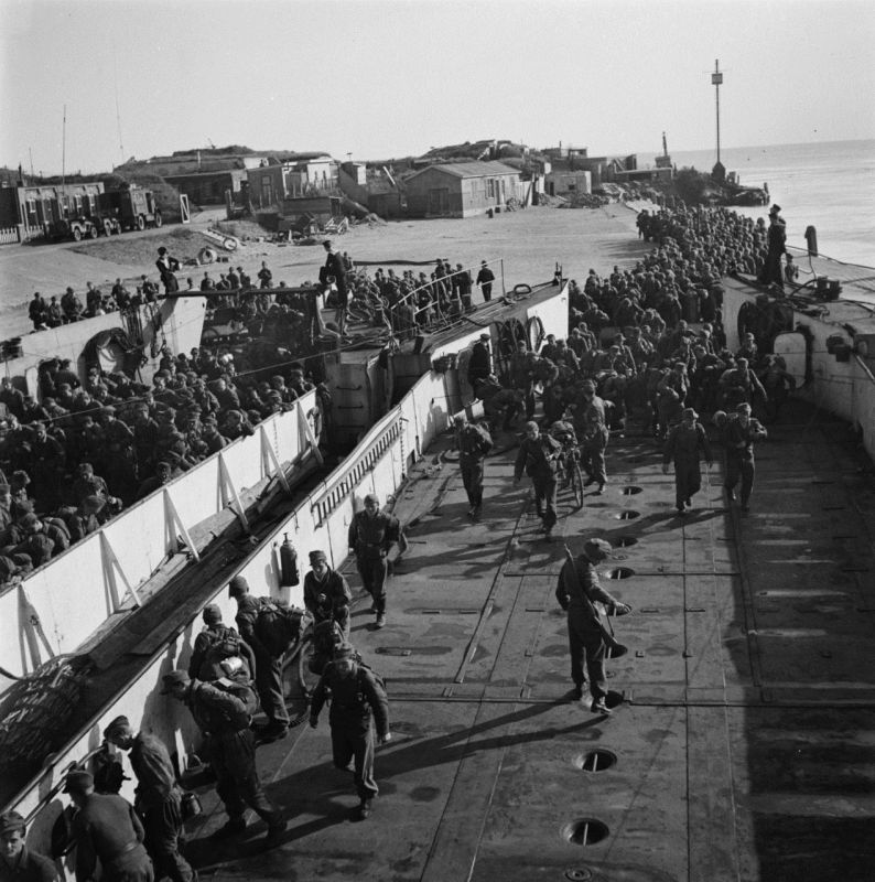 Пленные солдаты 6-й немецкой парашютной дивизии садятся на баржи в голландском Ден-Хелдере