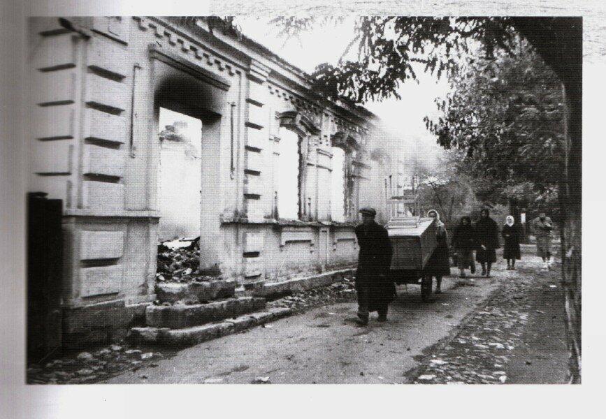 Мариуполь после второй мировой войны - люди идут вдоль разрушенного здания