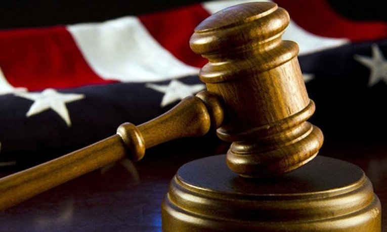 Судейский молоток на фоне американского флага &mdash; символ судебной системы США