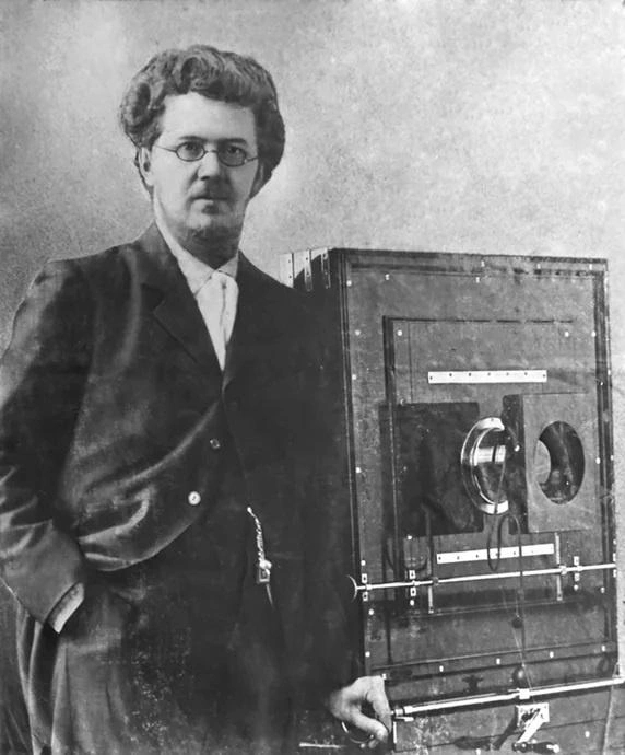 Портрет фотографа Вениамина Метенкова с крупной фотокамерой