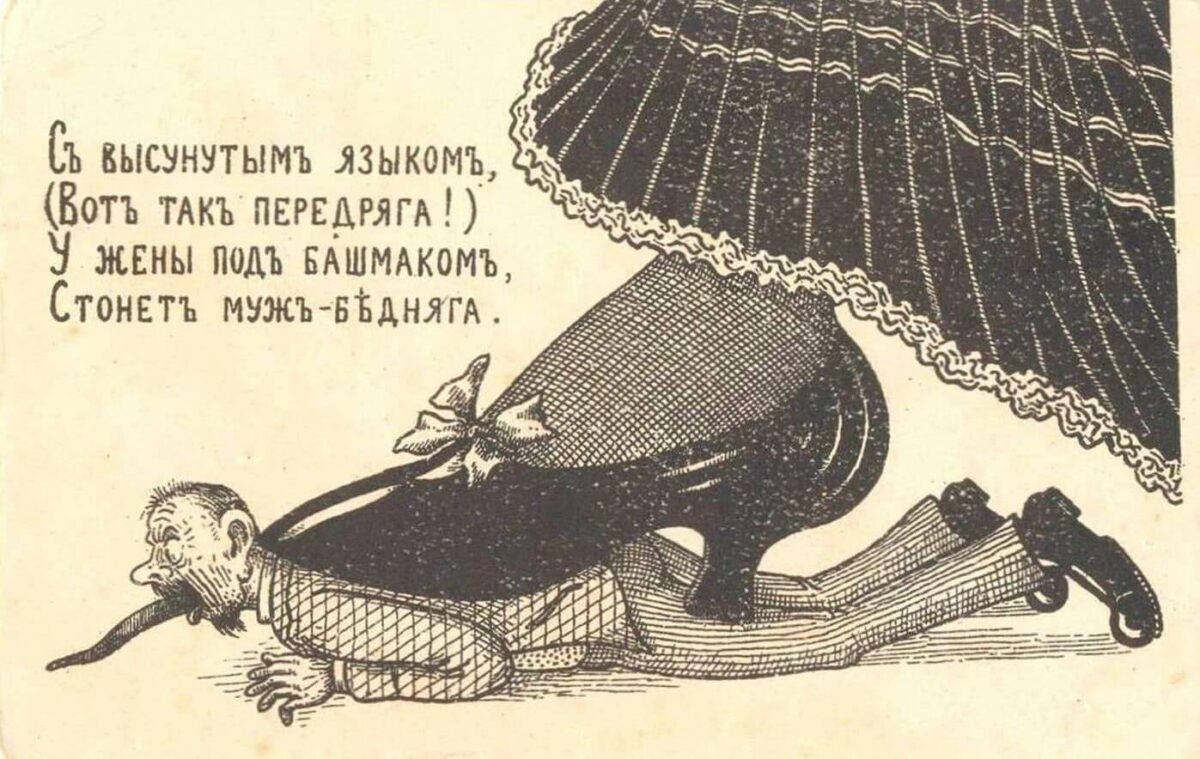 Юмористическая дореволюционная открытка с мужем, лежащим под огромным башмаком жены и высунувшим язык 