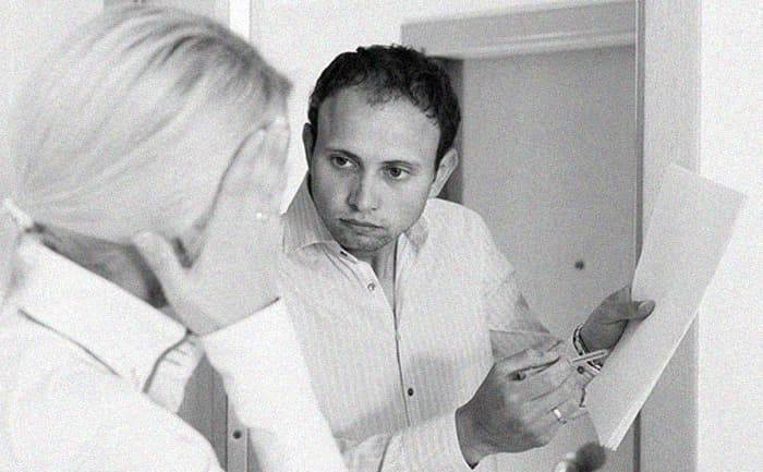 Старая деревянная дверь заброшенной квартиры в мансарде с облупившейся краской