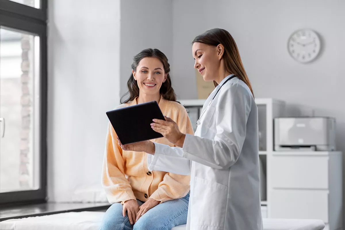 Женщина-миллениал на профилактическом осмотре у врача с планшетом