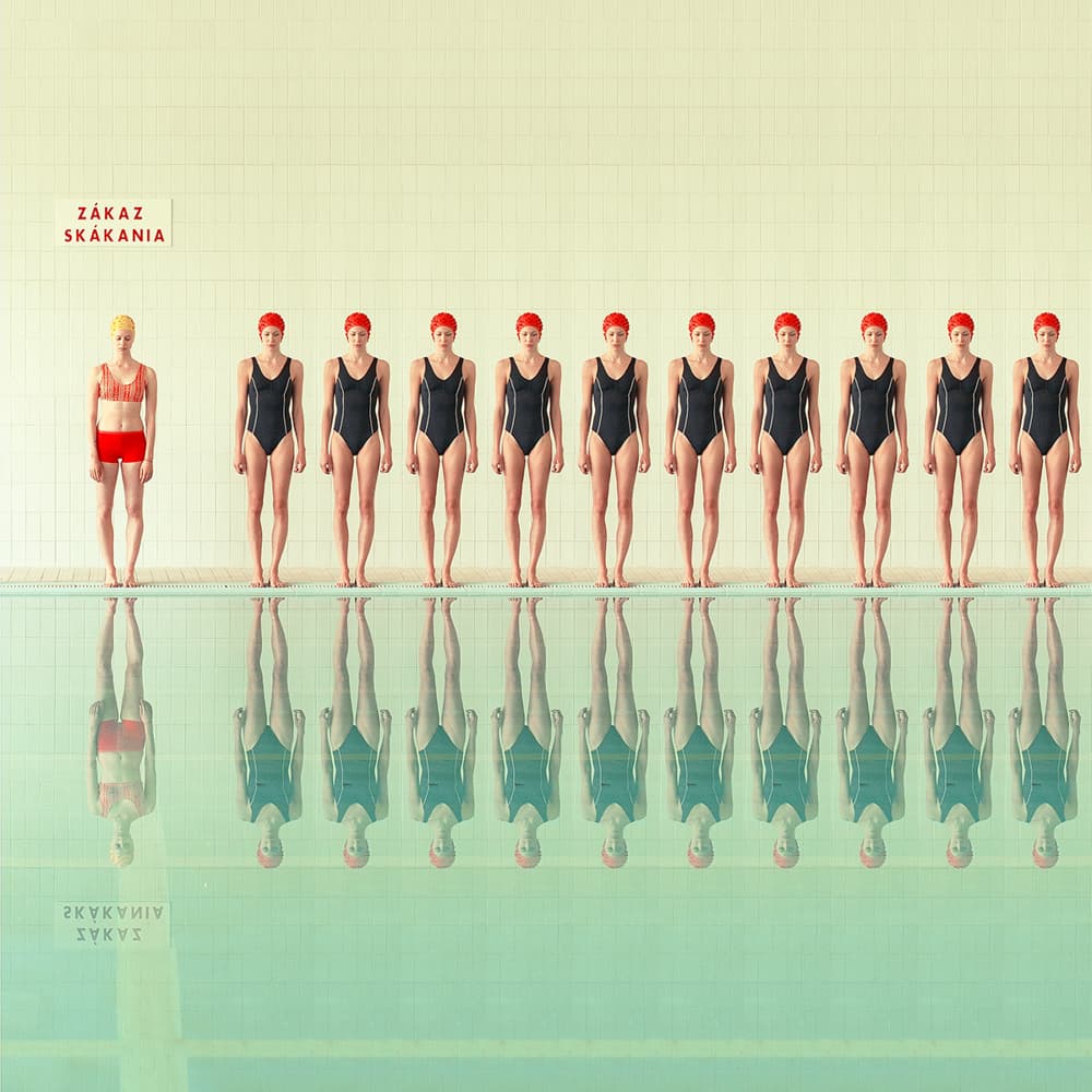 Женщина в белом костюме стоит за прилавком с десертами и свечами в розовой комнате