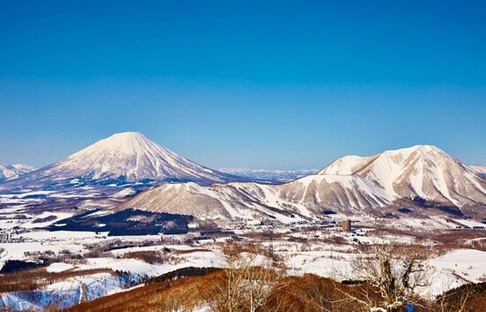 Заснеженный зимний пейзаж Хоккайдо с высокими горами, покрытыми густым снегом