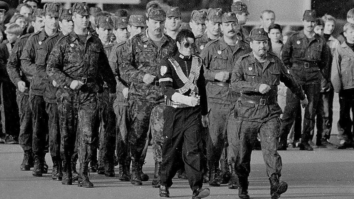 Черно-белый кадр российских солдат в военной форме перед которыми марширует Майкл Джексон