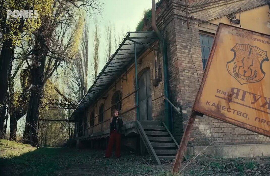 кадр из сериала - героиня на улице, вывеска на переднем плане