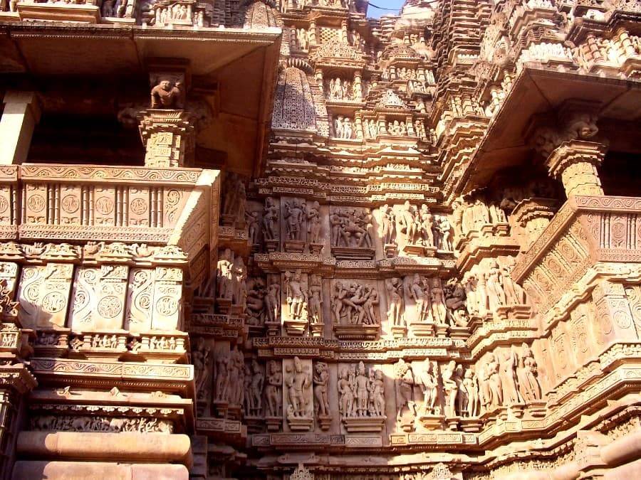 Резные скульптуры и колонны на фоне неба в храмовом комплексе Кхаджурахо