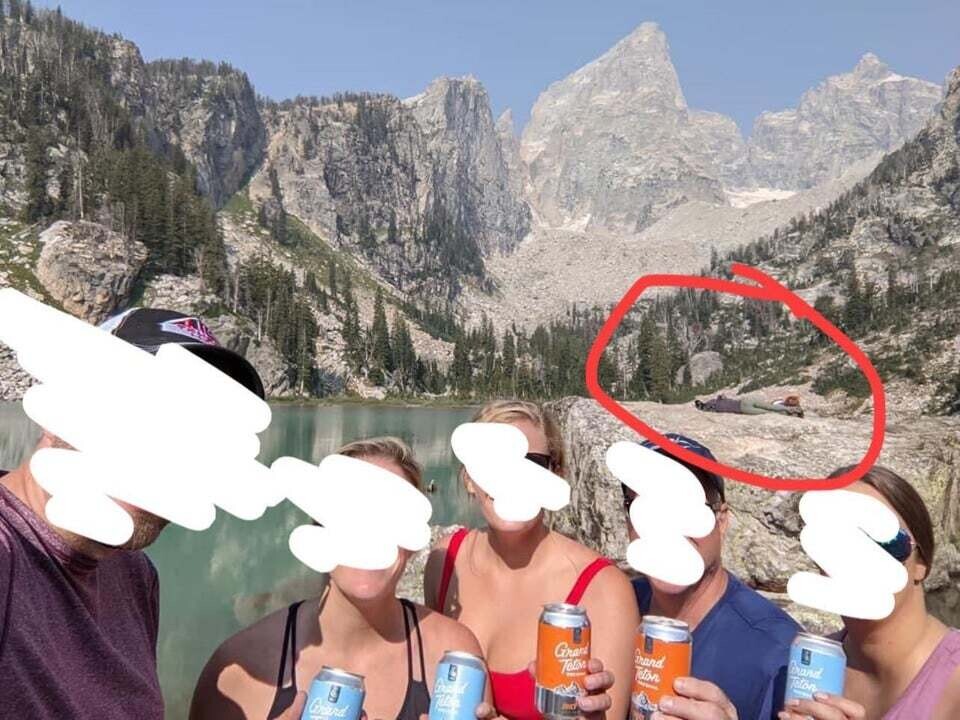 Групповое фото друзей на фоне озера и гор Гранд-Титон с обведённым силуэтом на скале