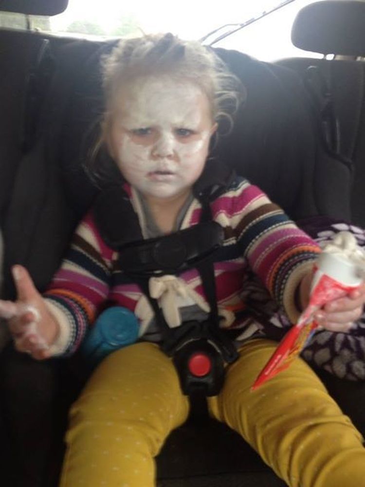 Ребёнок с белой мазью на всём лице сидит в кресле