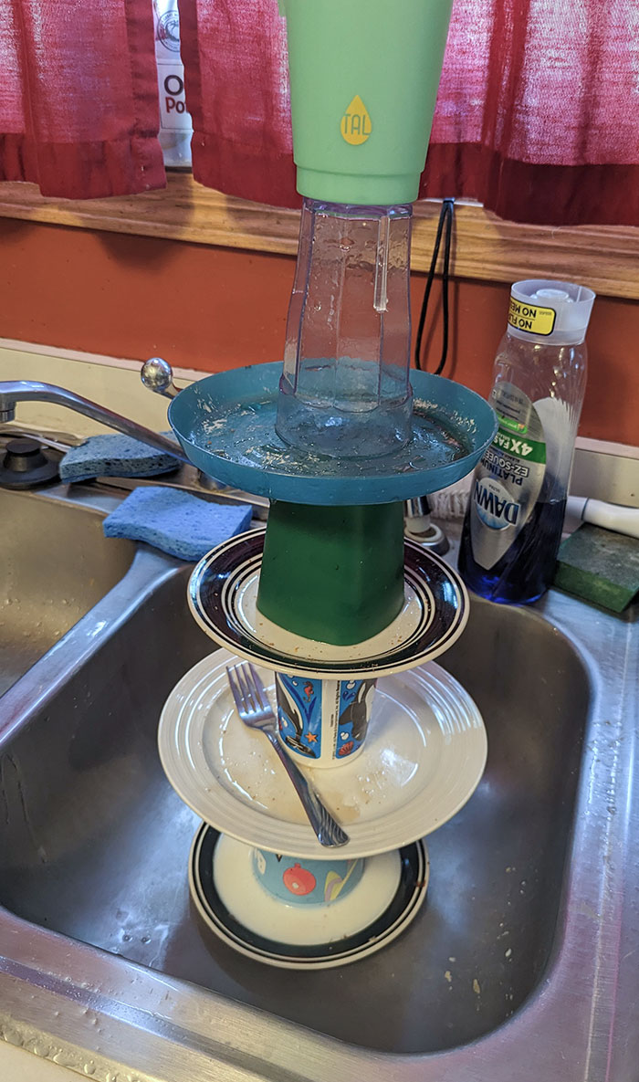 Гора посуды перевёрнута вверх дном в раковине