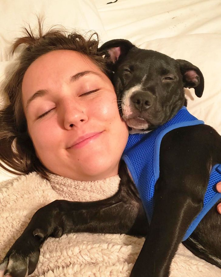 Девушка спит, а щенок стаффордширского терьера уютно устроился у неё на груди