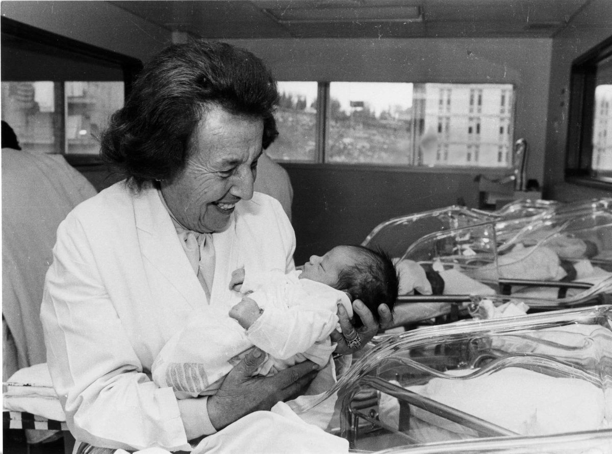 Пожилая Гизелла Перл держит новорождённого в госпитале Нью-Йорка