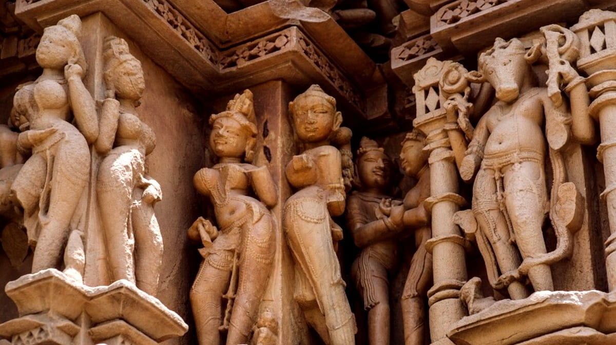 Скульптура небесной танцовщицы апсары в грациозной позе на стене храма