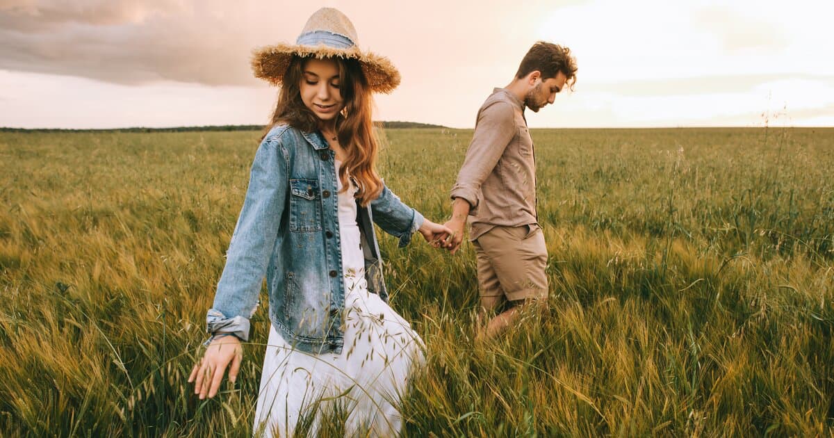 Человек читает книгу, сидя на берегу озера на закате, что иллюстрирует принципы Slow Life: наслаждение моментом и медленное чтение