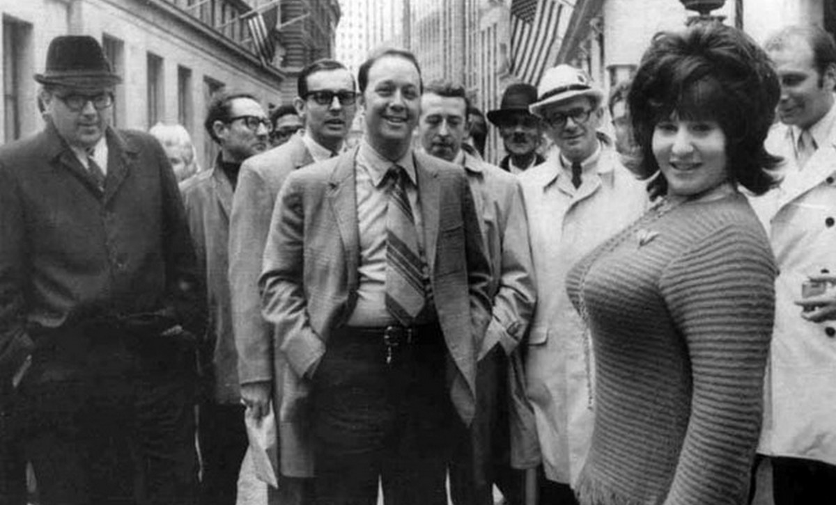 Франсин Готтфрид идет по Уолл-стрит в обтягивающем свитере среди толпы поклонников 1968