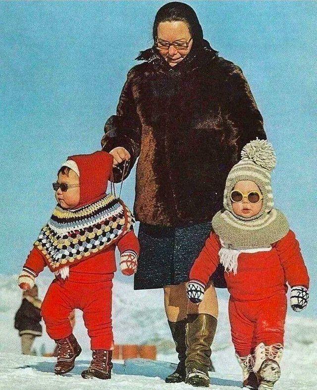 Дети идут с пожилой женщиной по улице в Гренландии, 1973 год
