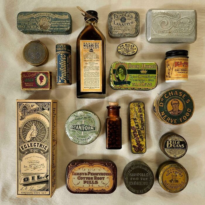 Антикварные аптечные баночки, коробочки и бутылочки от лекарств XIX века на столе