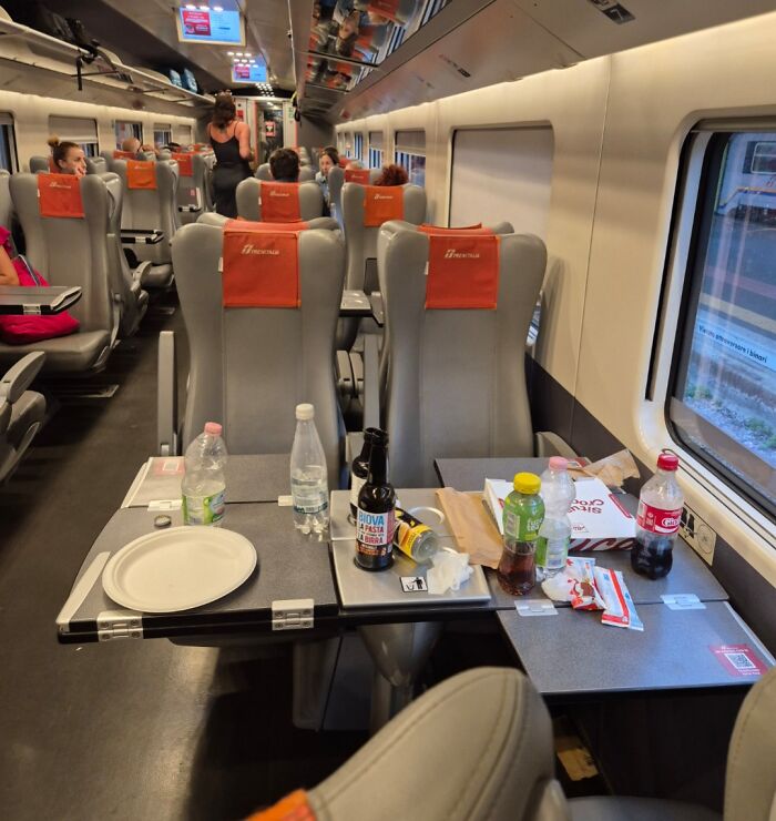 Столик в поезде завален бутылками водой едой и мусором